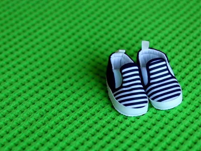 prikaz muških dečijih papučica plave boje na prugice na zelenoj pozadini